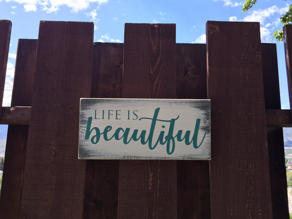 Life is Beautiful sign on pine